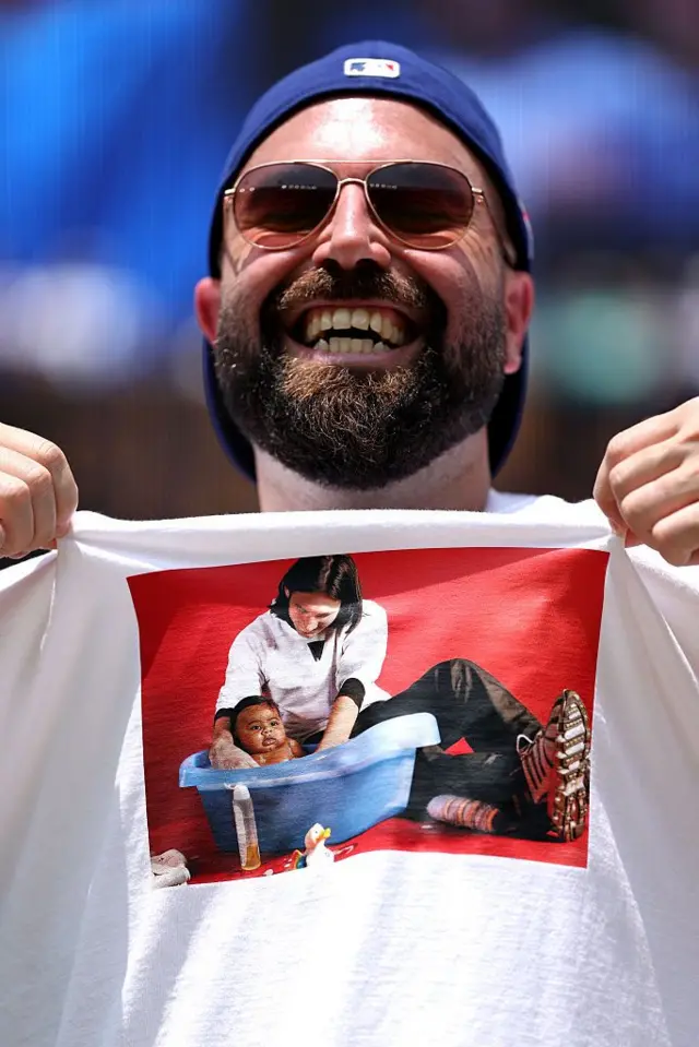 Torcedor sorri usando camiseta estampada com a foto em que Messi dá banho em Yamal, ainda bebê