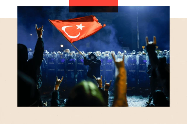 Туркия полицияси сафи олдида Туркия байроғини ҳилпиратиб турган намойишчи