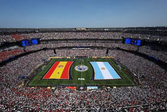 Las banderas de España y Argentina aparecen desplegadas en el césped del estadio de Nueva Jersey, EE.UU., antes de la final del Mundial 2026.