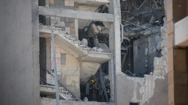Emergency personnel work inside a damaged building in Haifa following an Iranian missile strike on Israel, on 20 June 2025