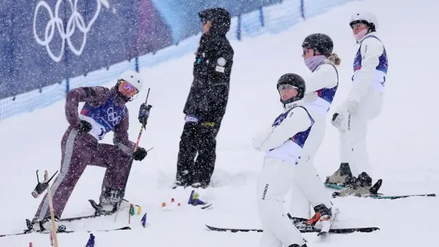 Спортсмены на склоне под падающим снегом