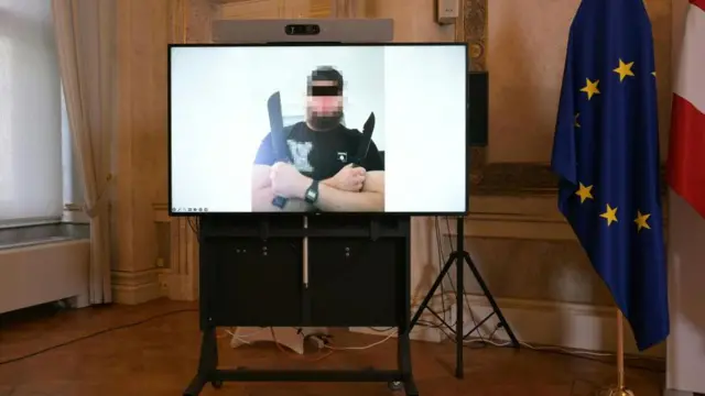 Zdjęcie jednego z trzech podejrzanych aresztowanych w związku z udaremnionym atakiem na koncert Taylor Swift w Wiedniu. Brodaty mężczyzna w czarnej koszulce trzyma dwa długie noże. Zdjęcie z 8 sierpnia 2024 r. 