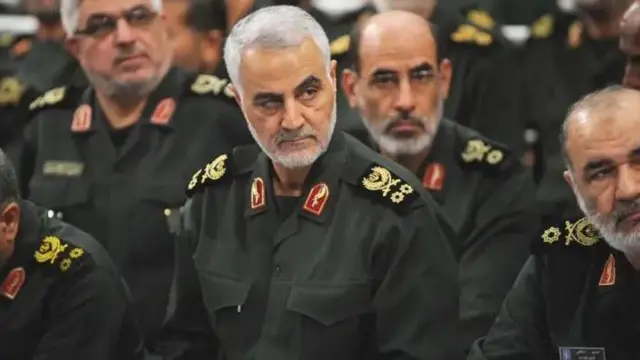 قاسم سلیمانی و حسین سلامی با لباس نظامی در کنار هم نشسته‌اند