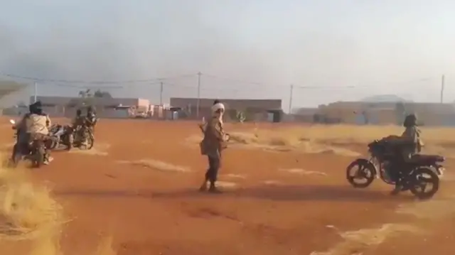 يتجمع مسلحون يحملون أسلحة في جيبو، بوركينا فاسو، حيث تعرضت قاعدة عسكرية للهجوم في هذه الصورة الثابتة التي أُخذت من مقطع فيديو على وسائل التواصل الاجتماعي، في مايو/أيار.