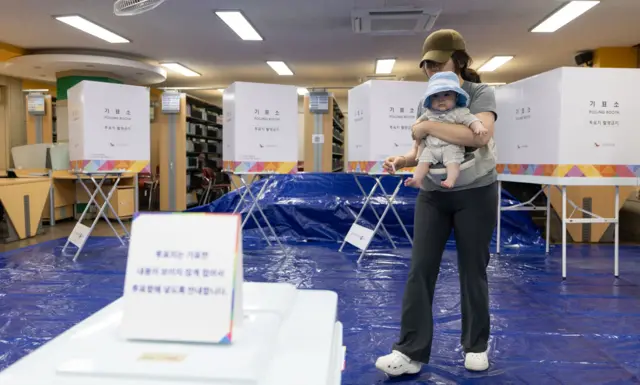 제21대 대통령 선거일인 3일 서울 영등포구 여의도 윤중중학교에 마련된 투표소를 찾은 시민이 아기와 투표하고 있다