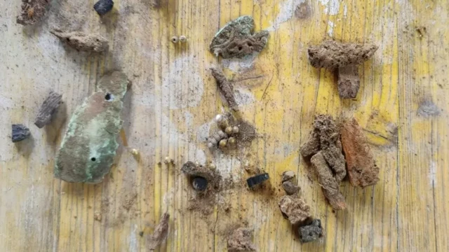 Contas de vidro douradas com ouro, além de uma fivela de cinto dourada foram encontradas no túmulo