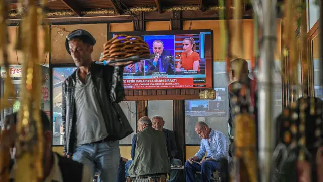 Diyarbakır'da bir kahvehane. Televizyonda "PKK fesih kararıyla silah bıraktı" yazıyor