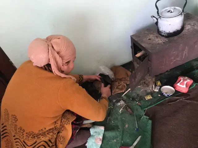 Uyidagi pechkaga o‘tin taxlayotgan ayol