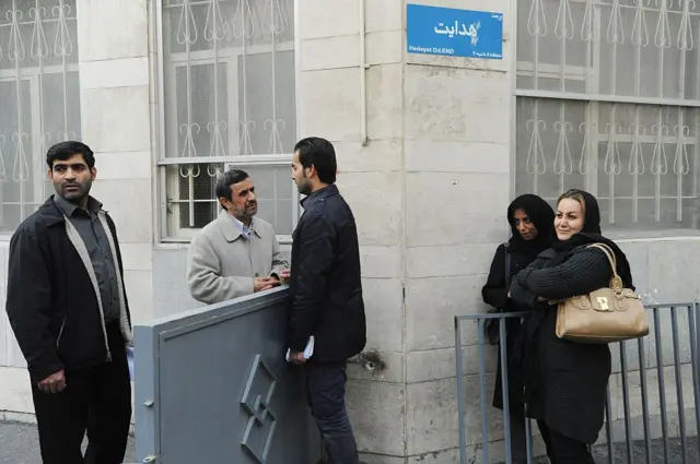 محمود احمدینژاد، رئیسجمهور پیشین ایران، با مراجعین بیرون از خانهاش در محله نارمک تهران صحبت میکند و نامههای درخواست کمک را از مردم دریافت میکند. نوامبر ۲۰۱۴