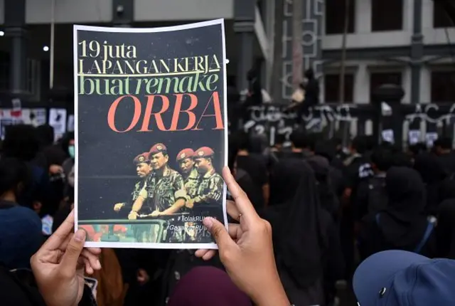 Ratusan demonstran membawa poster selama demonstrasi menentang pengesahan undang-undang TNI di depan gedung parlemen lokal di Malang, Jawa Timur, Indonesia, pada 23 Maret 2025.