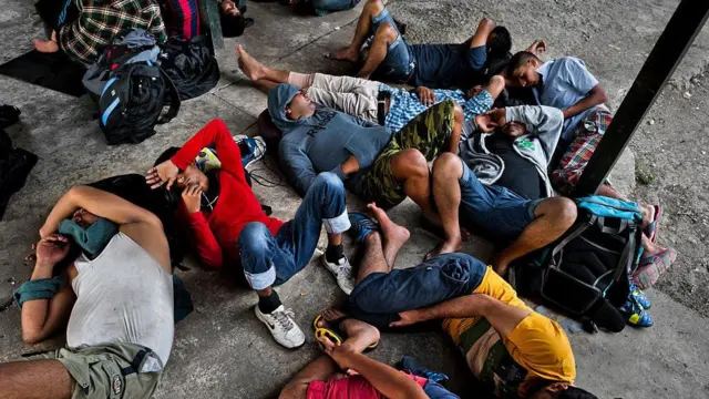 যুক্তরাষ্ট্রের দক্ষিণ সীমান্তের দিকে যাওয়ার পথে নেপালি অভিবাসীরা ড্যারিয়েন গ্যাপের জঙ্গল পাড়ি দেওয়ার পর সীমান্ত চেকপয়েন্টে ক্লান্ত হয়ে মাটিতে শুয়ে পড়েছেন। ২০১৫ সালের ২৮শে জানুয়ারি পানামার ড্যারিয়েন অঞ্চলে এই দৃশ্য দেখা যায়। 