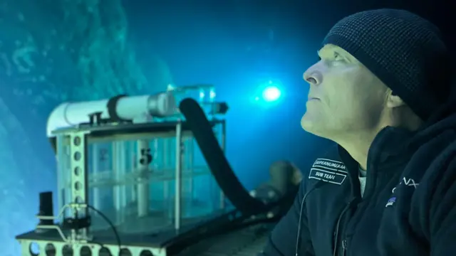 David Lochridge dentro de um submersível olhando o mar 