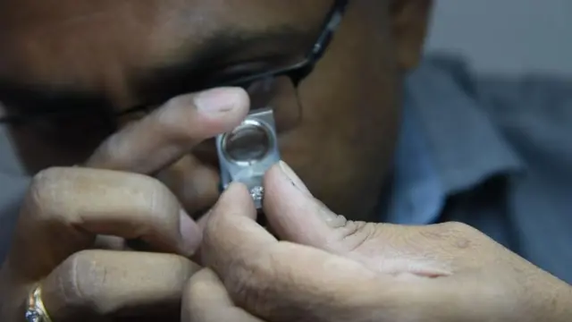 हिऱ्याची पारख करताना व्यापारी