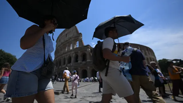 Roma’da Kolezyum yakınlarında insanlar şemsiyelerle güneşten korunuyor