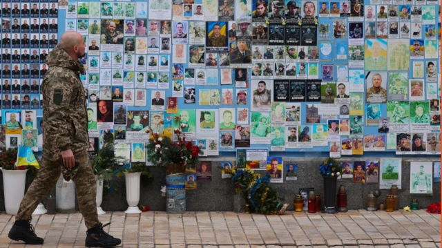 عسكري وصور راحلين وباقات ورد على الرصيف