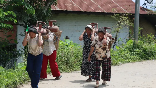 डोकोमा ग्यास बोकिरहेका महिलाहरू