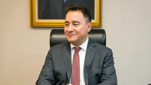Ali Babacan üzerinde bir takım elbiseyle otururken