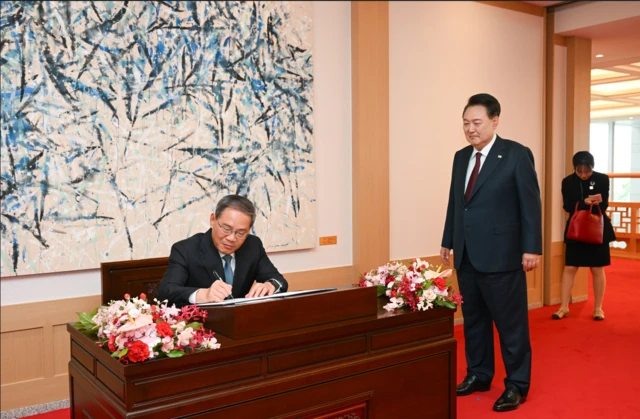 윤석열 대통령이 26일 용산 대통령실 청사에서 열린 한중 양자회담에 앞서 리창 중국 총리가 방명록을 작성하는 모습을 지켜보고 있다