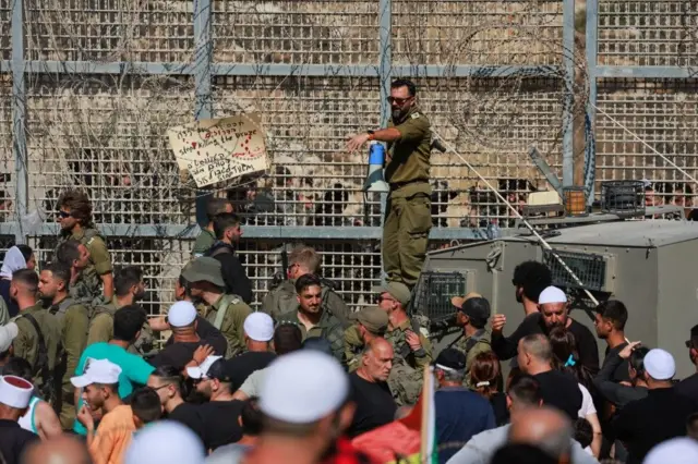 Izraelski vojnik drži megafon dok se izraelski Druzi okupljaju, blizu linije prekida vatre između Golanske visoravni koju je Izrael okupirao i Sirije