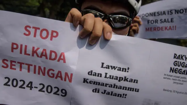 Pengunjuk rasa yang tergabung dalam aliansi mahasiswa dan masyarakat memegang poster saat berunjuk rasa di depan Gedung DPRD Jawa Barat, Bandung, Jawa Barat, Kamis (22/8/24).
