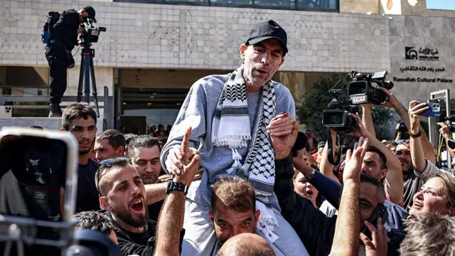 فلسطينيون يحتفلون ويحملون شخصاً فوق الأعناق