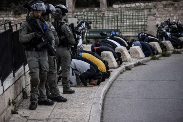 فلسطينيون يؤدون صلاة الجمعة في الشارع بسبب إبعاد الشرطة الإسرائيلية للشباب الفلسطيني من الوصول إلى المسجد الأقصى