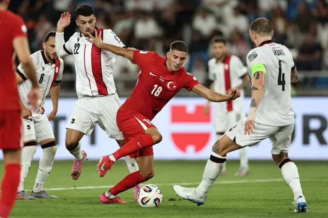 Mert Müldür, kendisini durdurmaya çalışan Gürcü futbolcuların arasından kıvrak hareketlerle ilerlerken