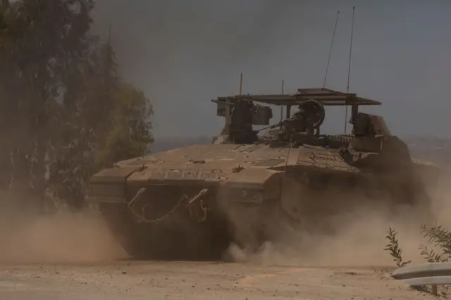 ناقلة جنود إسرائيلية تسيرعلى طول الحدود مع قطاع غزة وسط الرمال في 28 يونيو/حزيران 2024.