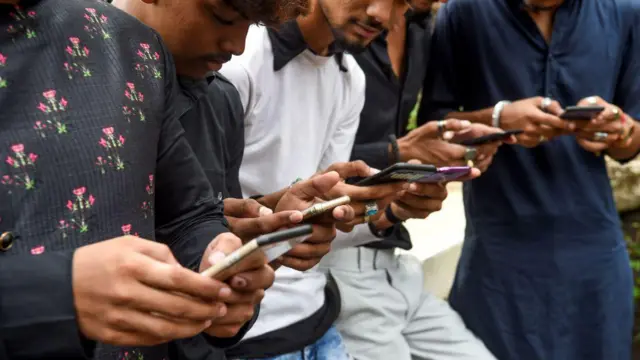 Jóvenes con sus teléfonos móviles.