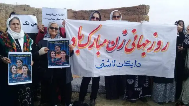 عکسی از مراسم روز ۸ مارس در حالیکه زنان عکس‌های وریشه مرادی، پخشان عزیز و شریفه محمدی را در دست گرفتند. 