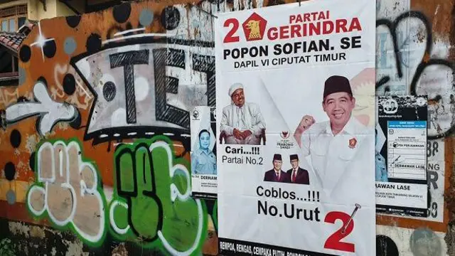 Poster calon anggota legislatif tertempel di tembok warga di Tangerang Selatan pada Pileg 2019.