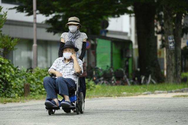 Una pareja de personas mayores, uno de ellos en silla de ruedas. 