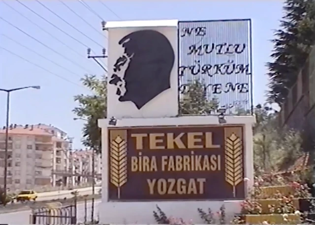 Fabrikanın ana girişinini fotoğrafı. Atatürk resmi ve "Ne mutlu Türküm diyene" yazısı bulunuyor. 
