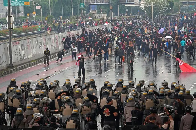 Para demonstran bentrok dengan polisi anti huru hara selama protes di luar gedung parlemen di Jakarta, Indonesia, pada hari Kamis, 28 Agustus 2025