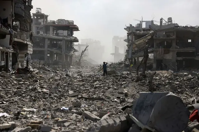 شاب فلسطيني يقف في شارع مليء بالأنقاض إثر انفجار في حي الصفطاوي، غرب جباليا شمال قطاع غزة.