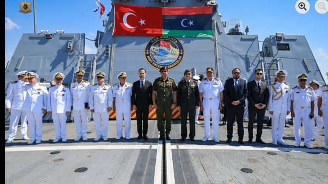 Türk ve Libyalı yetkililer TCG Kınalıada güvertesinde poz veriyor.