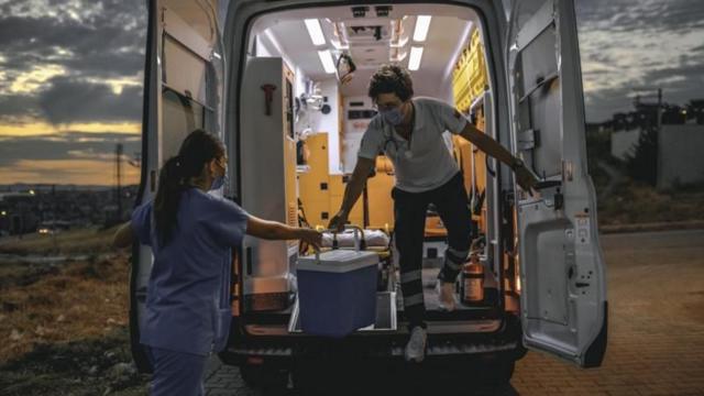Trabalhadores da área da saúde transportam órgão em ambulância