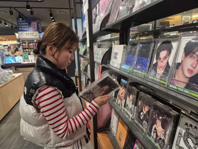 Gyu-ri browses K-pop albums at a music store in Seoul