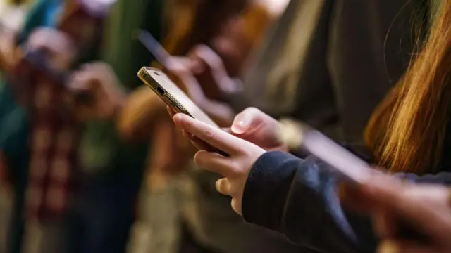 Akıllı telefonlarına bakan gençlerden oluşan bir grup.