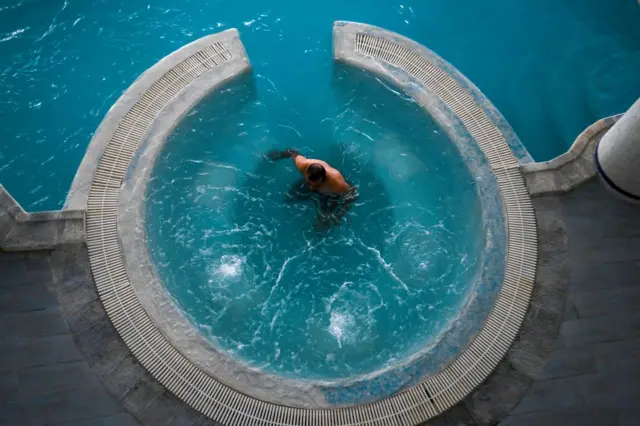 A man immerses himself in a round pool.
