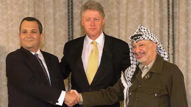 1999 yılında İsrail Başbakanı Ehud Barak (solda), ABD Başkanı Bill Clinton (ortada) ve Filistin Kurtuluş Örgütü (FKÖ) Başkanı Yaser Arafat, barış anlaşmalarının geçiş döneminin sona ermesinin ardından Oslo'da bir araya geldi. 