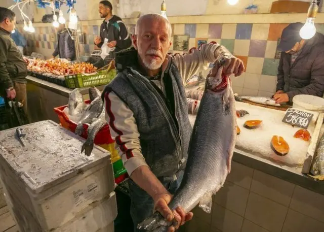 Un homme tenant un poisson