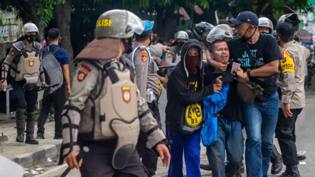 Polisi menangkap seorang mahasiswa saat unjuk rasa menolak UU Cipta Kerja di depan Gedung DPRD Sulawesi Tengah di Palu pada 8 Oktober 2020