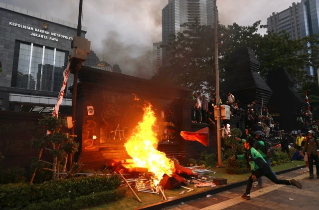 Pengunjuk rasa membakar water barrier saat aksi di depan Polda Metro Jaya, Jakarta, Jumat (29/8/2025).