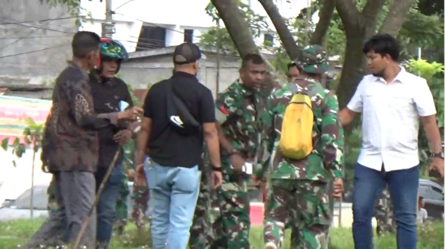 Tangkapan layar dari video yang merekam momen perampasan ponsel Fazil oleh anggota TNI di depan Kantor Bupati Aceh Utara, Kamis (25/12). Ada tujuh orang dalam tangkapan layar itu, tiga di antaranya mengenakan seragam TNI. Salah satu anggota TNI merampas ponsel milik Fazil.
