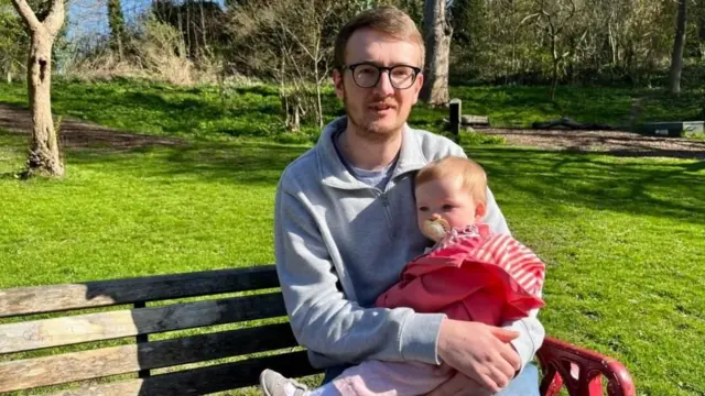 bir baba kızını kucağında tutuyor