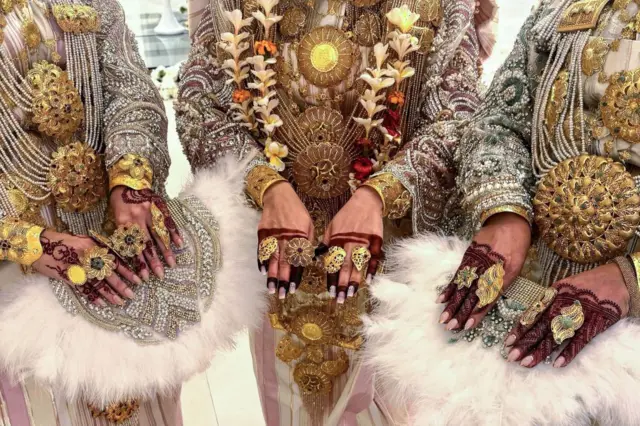 Mata sanye da kaya masu kwalliyar zinari da sarƙa da kuma lalle.