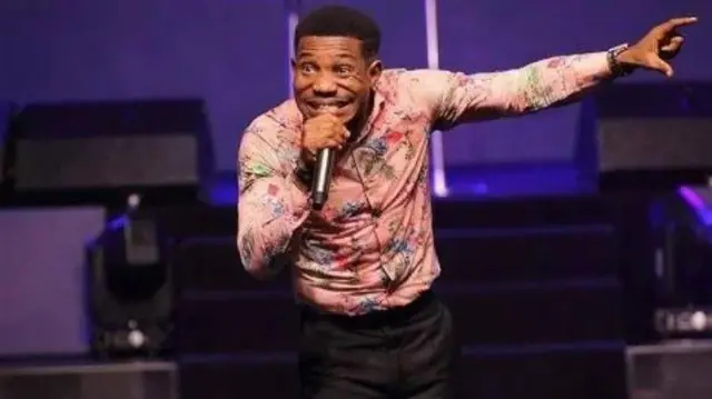 Pasitọ Jerry Eze n waasu, o mu gbohungbohun lọwọ lati sọrọ