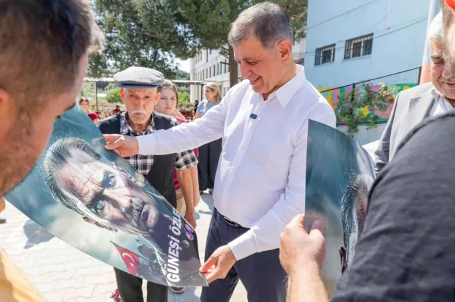 Cemil Tugay elinde Atatürk pankartı tutuyor