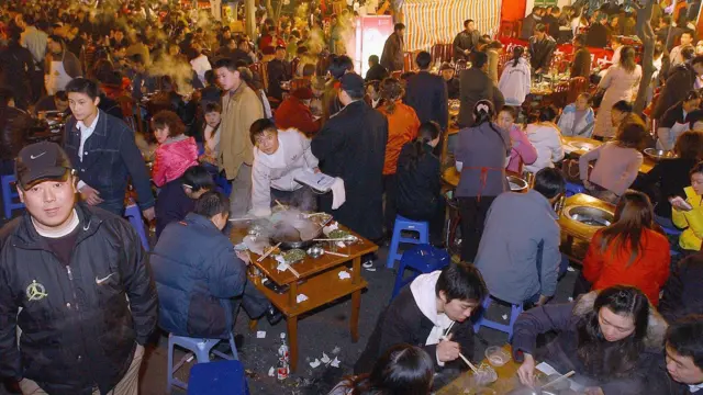 Namoonni mana nyaataa "hotpot" Chaayinaa Chengdu keessatti wayita shorbaa foon hoolaa nyaachaa jiran.